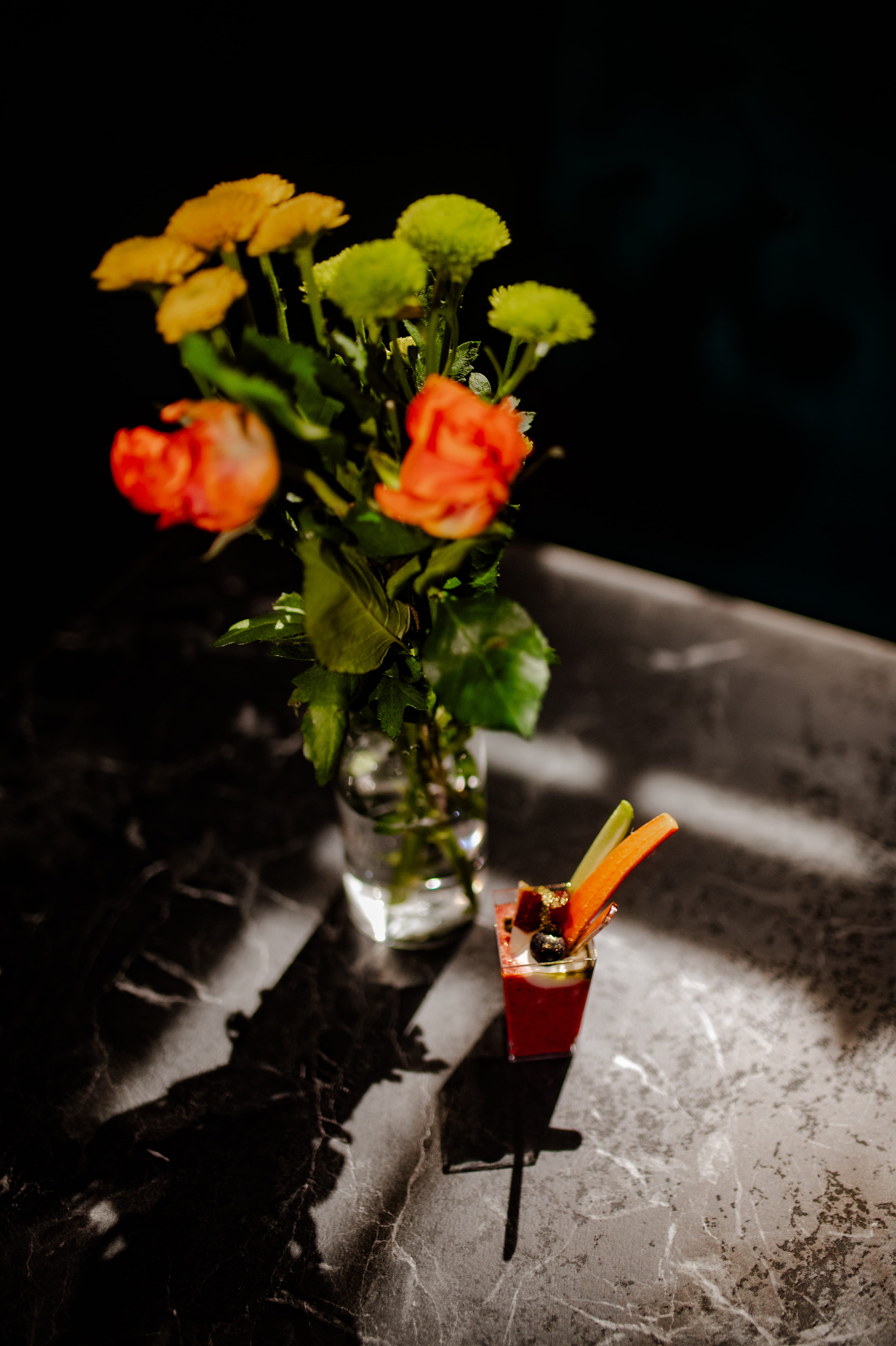 Seasonal blooms and a jewel-red serve on marble